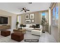 Staged living room featuring tile floors, furniture, and a ceiling fan at 9451 Natoma Station Pl, Las Vegas, NV 89123