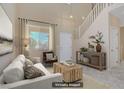 Staged living room with neutral paint, large windows, and a staircase leading to the second floor at 9451 Natoma Station Pl, Las Vegas, NV 89123