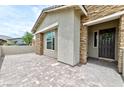 Stylish single story home showcasing the entrance, stone accents, an outdoor area, and paved driveway at 10972 Dixie Johnson Ave, Las Vegas, NV 89166