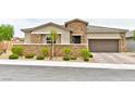 Charming single story home with stone accents, neat landscaping, and an attached two car garage at 10972 Dixie Johnson Ave, Las Vegas, NV 89166