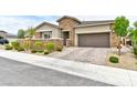 Charming single story home with stone accents, neat landscaping, and an attached two car garage at 10972 Dixie Johnson Ave, Las Vegas, NV 89166