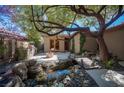 Beautiful backyard with pond, bridge, built-in grill, and fire pit, perfect for outdoor entertaining at 15 Emerald Dunes Cir, Henderson, NV 89052
