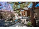 Backyard tranquility: pond, bridge, mature tree, and built-in BBQ create a perfect outdoor retreat at 15 Emerald Dunes Cir, Henderson, NV 89052