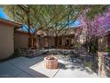 Serene backyard features lush greenery, a stone fire pit, and a tranquil pond with a wooden bridge at 15 Emerald Dunes Cir, Henderson, NV 89052