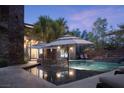 Inviting backyard pool with lounge chairs and umbrellas with manicured palm trees at 17 Soaring Bird Ct, Las Vegas, NV 89135