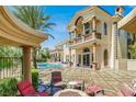 Picturesque backyard with pool, mature trees, and a cozy fire pit seating area at 2200 Glenbrook Way, Las Vegas, NV 89117