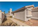 Side view of a cozy home showing the walkway and landscaping, plus a partially fenced-in yard at 2229 Bowstring Dr, Las Vegas, NV 89142