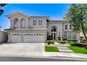 Beautiful two-story home showcasing a three-car garage, arched windows, and a well-maintained front yard at 2496 Ram Crossing Way, Henderson, NV 89074