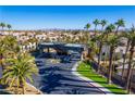 View of the community entrance showcasing palm trees and meticulously maintained landscaping. City skyline in the background at 4654 Stuttgart St, Las Vegas, NV 89147