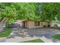 Exterior of the home with desert landscaping and mature trees providing shade at 5083 Village Dr, Las Vegas, NV 89142