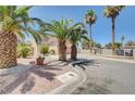 Two-story home with a two-car garage, palm trees, and desert landscaping for an appealing curb presence at 5907 Zawawi Ct, Las Vegas, NV 89110
