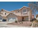 Two-story home with a tile roof, low maintenance desert landscaping, and a two-car garage at 5921 Royal Castle Ln, Las Vegas, NV 89130