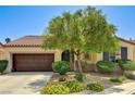 Charming single-story home featuring a well-manicured front yard with lush landscaping and a two-car garage at 6808 Mystic Plain Ct, Las Vegas, NV 89149