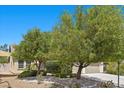 Well-maintained front yard featuring desert landscaping and mature trees for added curb appeal at 9233 Onyx Point Ct, Henderson, NV 89074