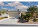 Charming single-story home featuring a two-car garage, desert landscaping and mature palm trees at 10240 Notte Ave, Las Vegas, NV 89135