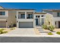 Charming two-story home featuring a balcony, gray-tone stucco, a paver driveway, and minimalist desert landscaping at 10429 Rose Palisade St, Las Vegas, NV 89141
