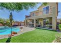 Expansive backyard with a pool, covered patio, and upper balcony at 10656 Hyde Corner Ave, Las Vegas, NV 89166