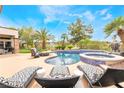 Resort-style pool area with sun loungers, spa, and lush landscaping at 11 Knob Oak Dr, Henderson, NV 89052