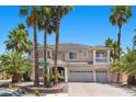 Beautiful two-story home with a three-car garage, manicured landscaping, and mature palm trees at 11056 Kilkerran Ct, Las Vegas, NV 89141
