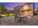 Private backyard with a paver patio, dining table, balcony and a small grassy area at 11274 Civita St, Las Vegas, NV 89141
