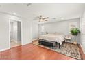 Spacious main bedroom with hardwood floors, a ceiling fan, and an ensuite bathroom at 11274 Civita St, Las Vegas, NV 89141