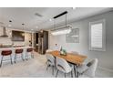 Contemporary dining area featuring a wood table, pendant lighting, and views of the kitchen at 11402 Ethereal Landing Ave, Las Vegas, NV 89138
