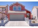 Charming coral two-story home featuring an attached two-car garage and easy-to-maintain landscaping at 1428 Daybreak Dr, Las Vegas, NV 89108