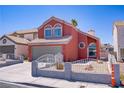 Charming coral two-story home featuring an attached two-car garage and low-maintenance desert landscaping at 1428 Daybreak Dr, Las Vegas, NV 89108