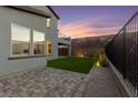 A paver patio and artificial turf area compliment the rear exterior of this home at 2004 Peaceful Mesa Ct, Henderson, NV 89052