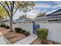 View of home featuring a small gated yard with an attractive blue gate and mature landscaping at 2132 Chertsey Dr # B, Las Vegas, NV 89108
