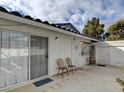 View of the outdoor patio area with sliding glass door, outdoor lights and two chairs at 2132 Chertsey Dr # B, Las Vegas, NV 89108