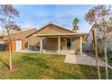 Lush backyard featuring a covered patio, manicured lawn, and convenient outdoor dining set at 3323 Bay Horse Ct, North Las Vegas, NV 89032