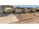 Charming exterior view with a covered driveway and minimalistic desert landscaping at 5905 Paseo Montana, Las Vegas, NV 89108