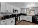 Modern kitchen featuring granite countertops, stainless steel appliances, and white cabinets at 5905 Paseo Montana, Las Vegas, NV 89108