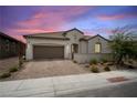 Charming single-story home featuring a brick driveway, neutral stucco, tile roof, and desert landscaping at 717 Monroe Hill Pl, Henderson, NV 89011