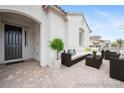 Cozy staged front porch with neutral furniture and a dark front door at 717 Monroe Hill Pl, Henderson, NV 89011