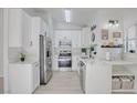 Bright kitchen featuring white cabinetry, stainless steel appliances, marble countertops, and a modern design at 7405 Saybrook Point Dr, Las Vegas, NV 89128