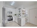 Modern white kitchen with stainless steel appliances, marble countertops, and stylish black fixtures offers an elegant design at 7405 Saybrook Point Dr, Las Vegas, NV 89128