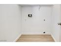A bright, empty laundry room, ready for appliances, featuring clean white walls and modern wood-look flooring at 7405 Saybrook Point Dr, Las Vegas, NV 89128