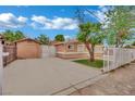 A lovely single story home with a well-maintained lawn, mature trees, and a gated driveway at 75 N 27Th St, Las Vegas, NV 89101