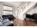 Spacious living room featuring hard wood floors, a gray sofa, and large windows providing plenty of natural light at 8860 Hampton Green Ave, Las Vegas, NV 89129