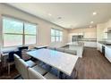 Open-concept area featuring wood-look tile, natural light, and a view of the modern kitchen at 10879 Artesano Ave, Las Vegas, NV 89135