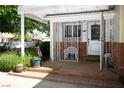 Welcoming front porch with a wrought-iron gate, mature plants, and stylish decor at 1115 Melville Dr, Las Vegas, NV 89102