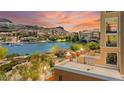 Balcony view overlooking the lake, showcasing waterfront homes and picturesque mountain views at sunset at 29 Montelago Blvd # 131, Henderson, NV 89011