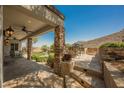 Charming outdoor living space featuring stone patio, outdoor kitchen and seating at 40 Stonemark Dr, Henderson, NV 89052