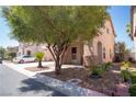 Tan colored two-story home with desert landscaping and covered front porch at 4945 Volcanic Rock Ln, Las Vegas, NV 89122