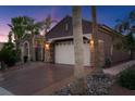 Exterior view showcasing a two-car garage with a concrete driveway and desert landscaping at 8209 Chapelle Ct, Las Vegas, NV 89131