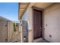 Welcoming covered front entry with a dark paneled front door and side access gate at 9357 Aria Ridge Ave, Las Vegas, NV 89143