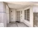 Close-up of covered front porch with security door, window, textured walls and concrete flooring at 1320 Rainbow Meadows Dr, Las Vegas, NV 89128