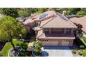 Aerial view of a two-story home showcases a tiled roof, solar panels, and a beautifully landscaped yard at 2208 Fiero Dr, Las Vegas, NV 89134